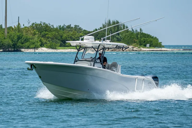 Slide: The Image of 2022 Sea Fox 288 Commander boat cruising on clear blue water near lush green shoreline. - 3
