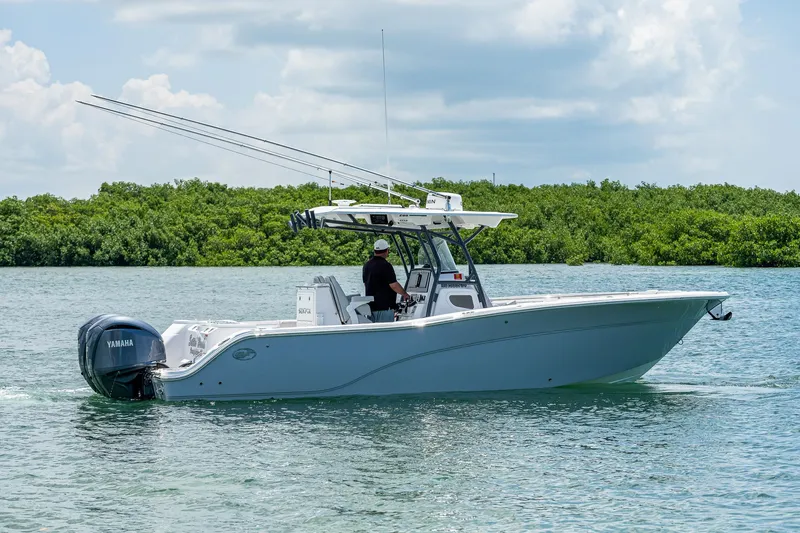 Slide: The Image of 2022 Sea Fox 288 Commander boat cruising on calm water with lush greenery in the background. - 6