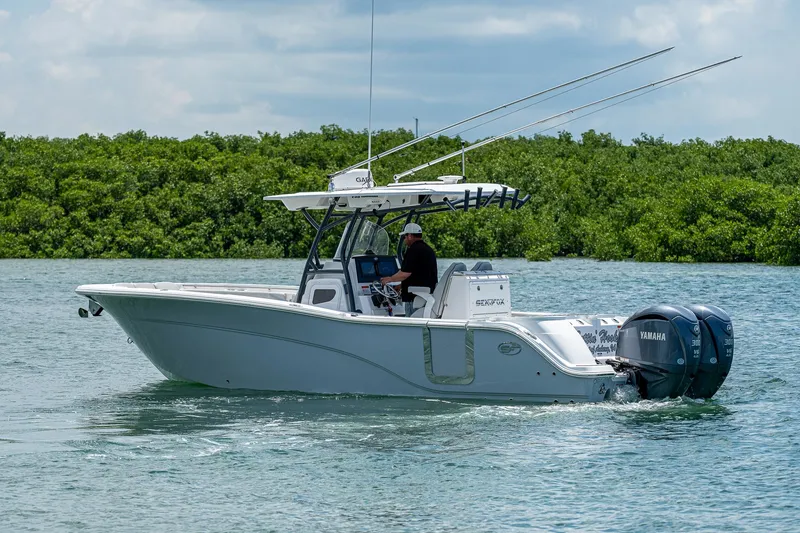 Slide: The Image of 2022 Sea Fox 288 Commander boat cruising on water with lush greenery in the background. - 8