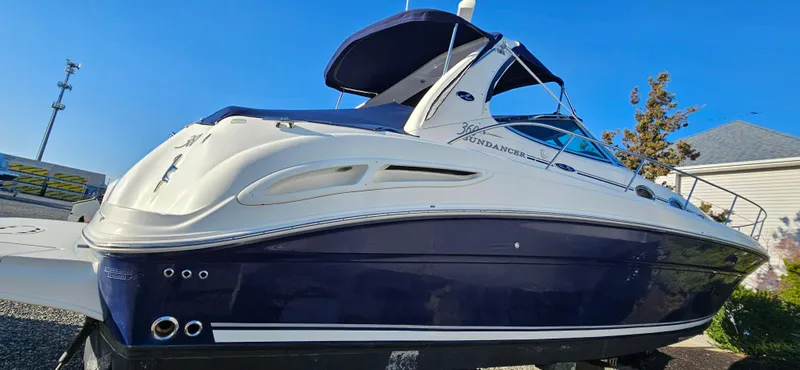Slide: The Image of 2005 Sea Ray 360 Sundancer boat with blue and white exterior, docked outdoors. - 0