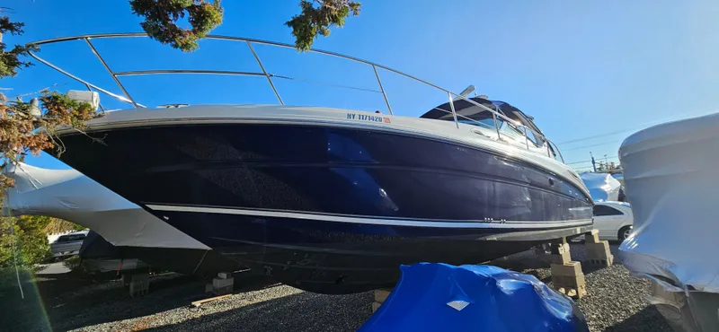 Slide: The Image of 2005 Sea Ray 360 Sundancer boat on dry dock, blue hull, sunny day. - 1