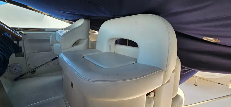 Slide: The Image of 2005 Sea Ray 360 Sundancer interior with white leather seating and blue cover. - 10