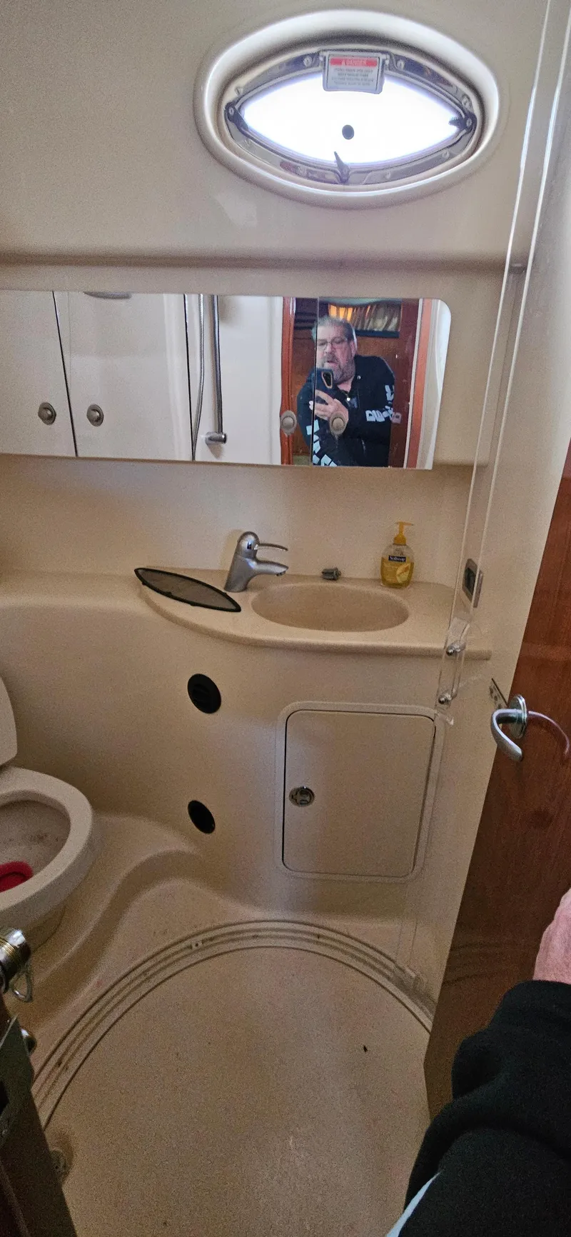 Slide: The Image of 2005 Sea Ray 360 Sundancer bathroom with sink, mirror, and porthole window. - 16