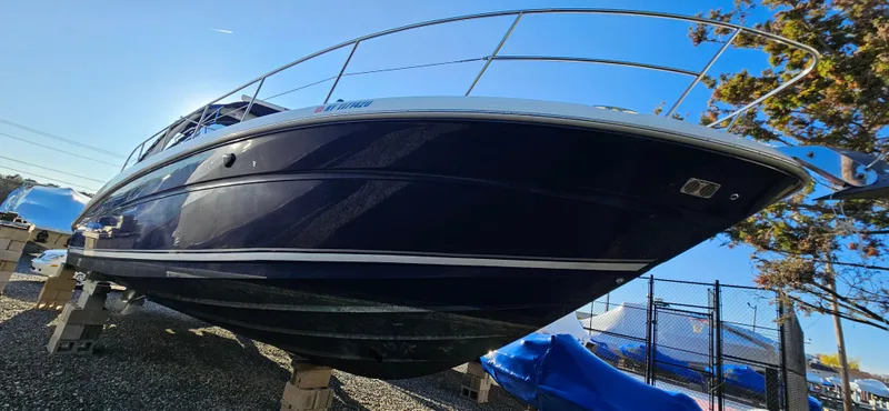 Slide: The Image of 2005 Sea Ray 360 Sundancer boat on blocks, side view, under clear blue sky. - 2