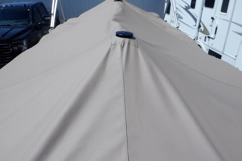 Slide: The Image of 2009 Premier 225 Sunsation LTD boat with beige cover, parked near vehicles. - 50