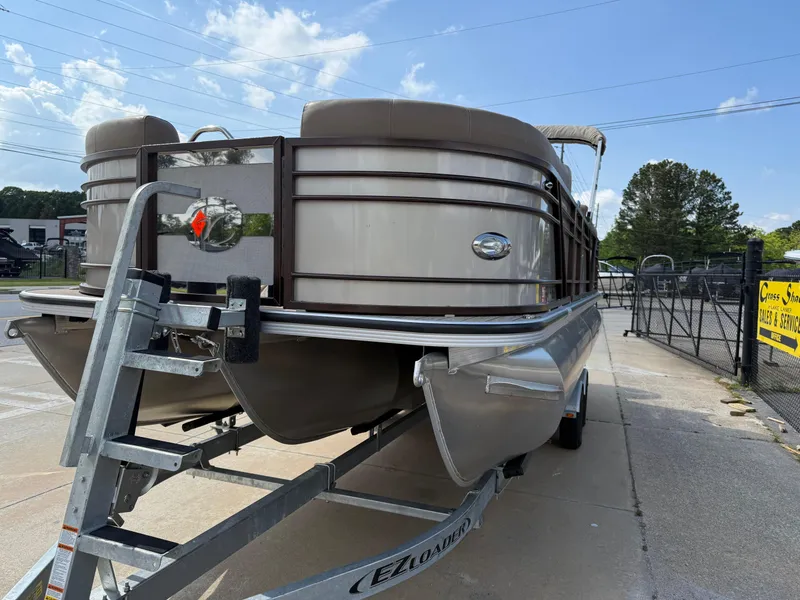 Slide: The Image of 2023 Veranda VTX 22RC pontoon boat on trailer, parked outdoors under a clear sky. - 23