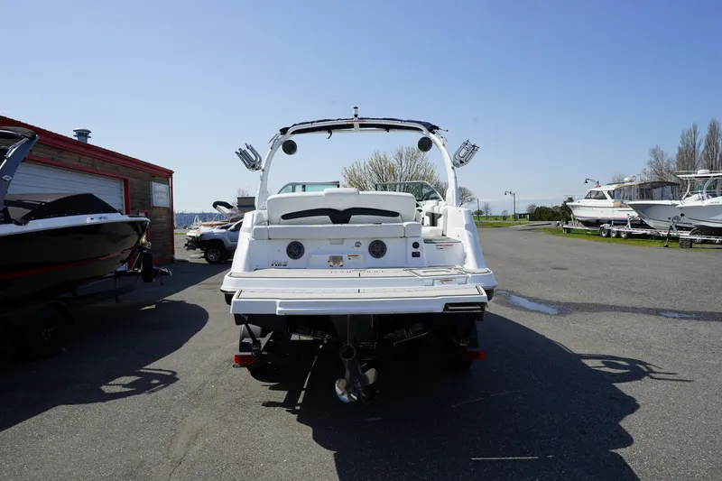 Slide: The Image of 2023 Four Winns HD3 Surf boat, rear view, parked outdoors on a sunny day. - 2