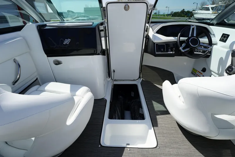 Slide: The Image of 2023 Four Winns HD3 Surf boat interior with white seating and open storage compartment. - 23