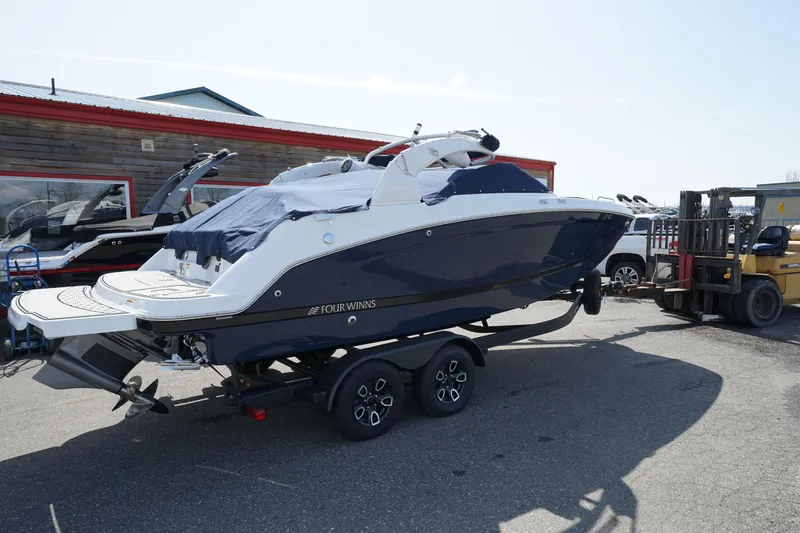 Slide: The Image of 2023 Four Winns HD3 Surf boat on trailer, parked outdoors. - 3