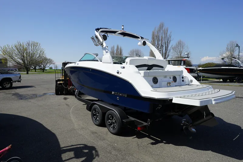 Slide: The Image of 2023 Four Winns HD3 Surf boat on trailer, parked outdoors on a sunny day. - 4