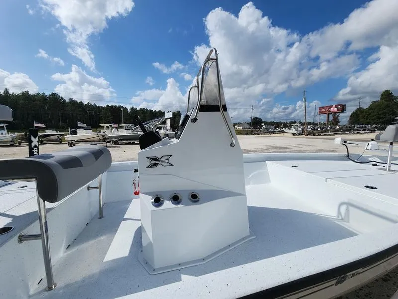 Slide: The Image of 2025 Xpress H210 BAY boat with console, outdoor setting, and blue sky background. - 12