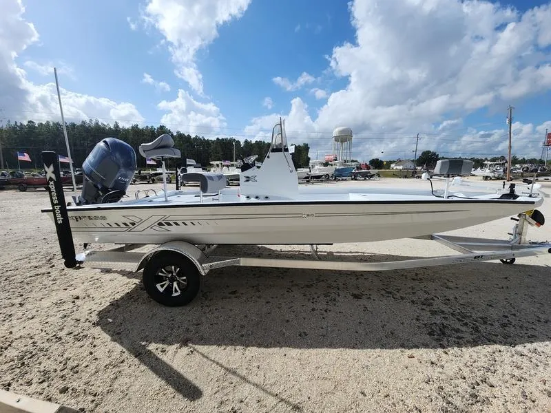 Slide: The Image of 2025 Xpress H210 BAY boat on trailer under a bright blue sky. - 2