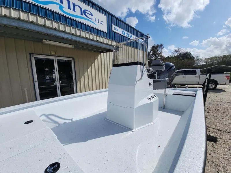Slide: The Image of 2025 Xpress H210 BAY boat displayed outside a marine dealership under a partly cloudy sky. - 5