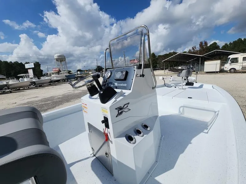 Slide: The Image of 2025 Xpress H210 BAY boat with console, parked outdoors under a cloudy sky. - 6
