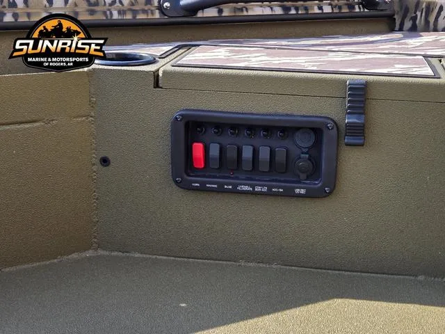 Slide: The Image of Control panel on 2025 Avid 16 Commander boat, featuring switches and cup holder. - 13
