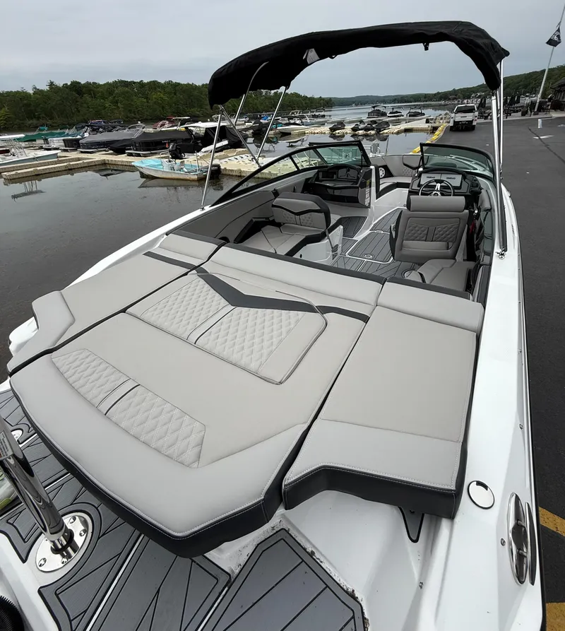 Slide: The Image of 2025 Monterey 235 Super Sport boat with sleek design and spacious seating at a marina. - 11