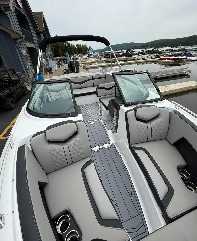 Slide: The Image of 2025 Monterey 235 Super Sport boat with luxurious seating at a marina. - 6