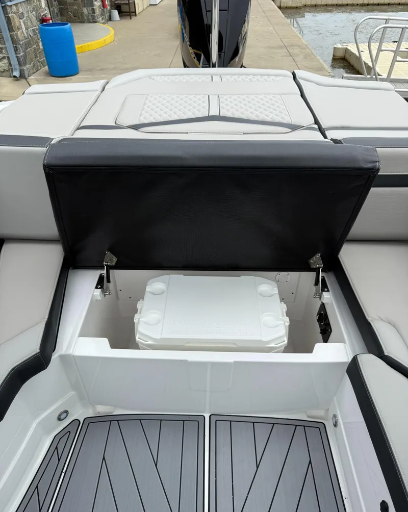Slide: The Image of 2025 Monterey 235 Super Sport boat with open storage compartment and cooler. - 9