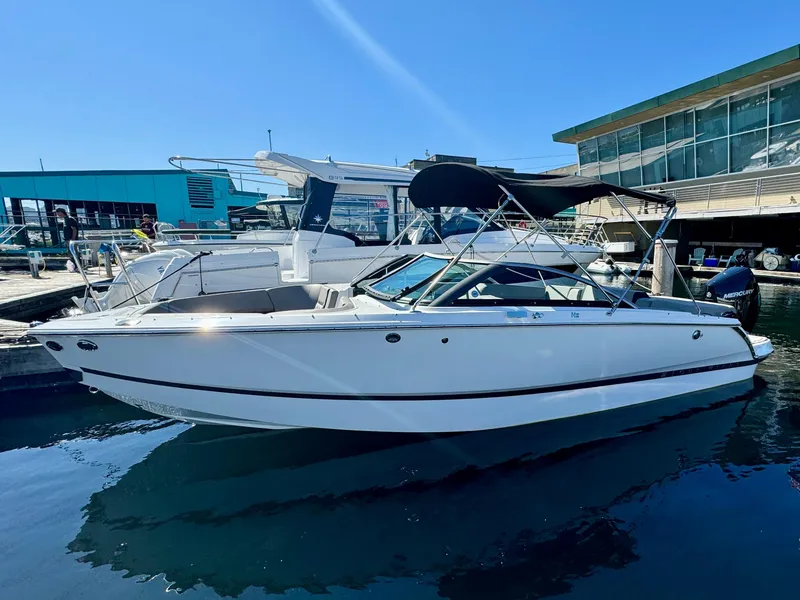 Slide: The Image of 2023 Four Winns H2 boat docked at marina under clear blue sky. - 0