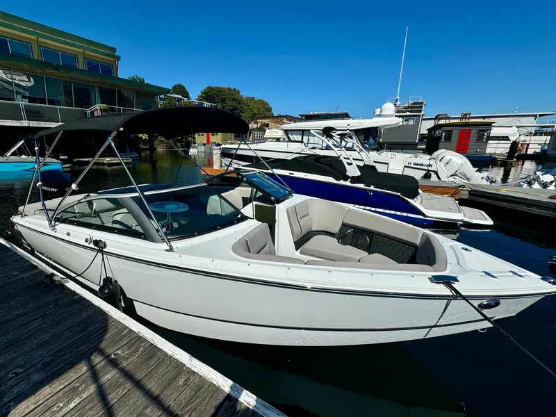 Slide: The Image of 2023 Four Winns H2 boat docked at marina under clear blue sky. - 4
