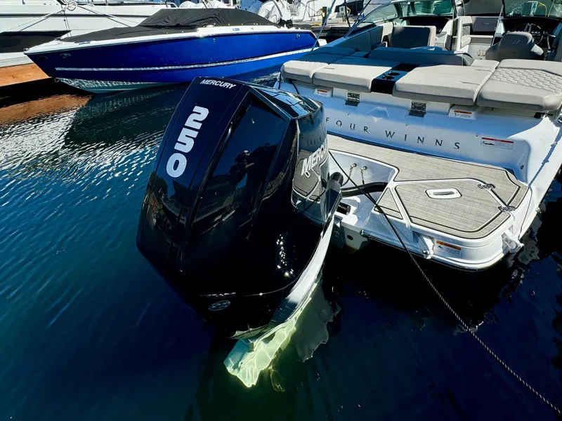 Slide: The Image of 2023 Four Winns H2 boat with Mercury 250 outboard engine docked in marina. - 6