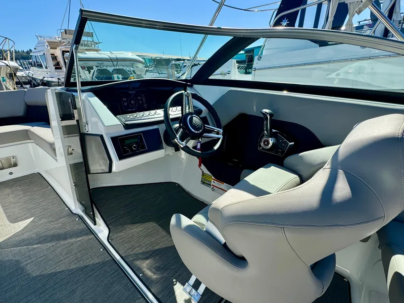Slide: The Image of 2023 Four Winns H2 boat cockpit with modern steering and controls, docked at marina. - 14