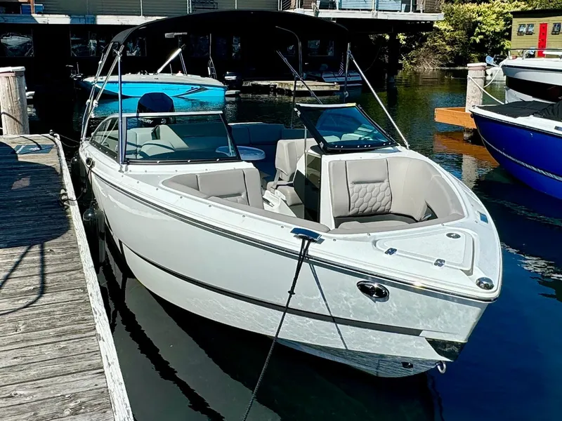 Slide: The Image of 2023 Four Winns H2 boat docked in a marina, featuring sleek design and comfortable seating. - 3