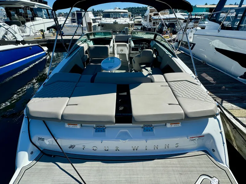 Slide: The Image of 2023 Four Winns H2 boat with spacious seating, docked at a marina. - 7