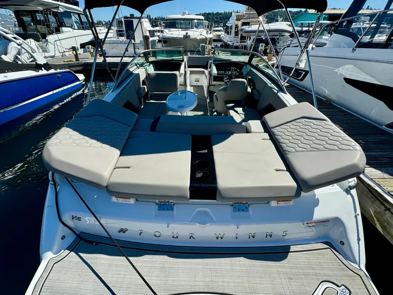 Slide: The Image of 2023 Four Winns H2 boat with spacious seating, docked at a marina. - 8