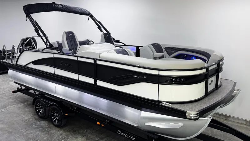 Slide: The Image of 2025 Barletta Corsa 23UC pontoon boat on trailer, sleek design, black and white color scheme. - 2