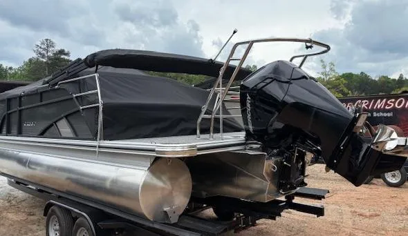 Slide: The Image of 2025 Crest Classic 220 pontoon boat with black cover and powerful outboard motor. - 11