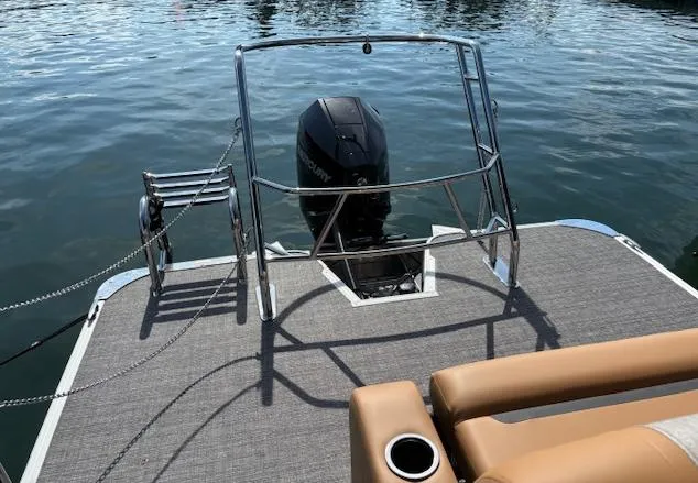 Slide: The Image of 2025 Crest Classic 220 boat with motor, rear deck view on water. - 6