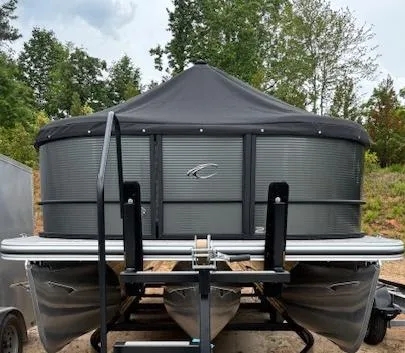Slide: The Image of 2025 Crest Classic 220 pontoon boat with black cover, parked outdoors. - 9