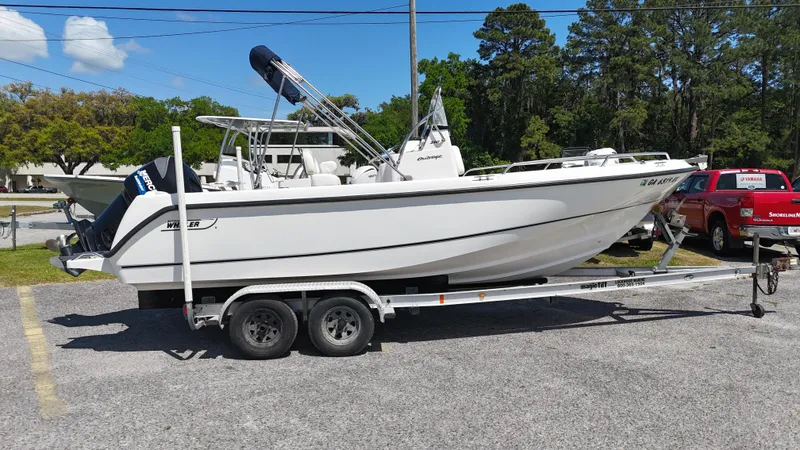 The Image of 2003 Boston Whaler 21 Outrage boat on trailer, parked outdoors. - 1