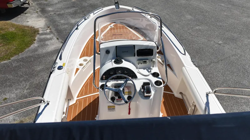 Slide: The Image of 2003 Boston Whaler 21 Outrage boat interior with steering console and wooden deck. - 12