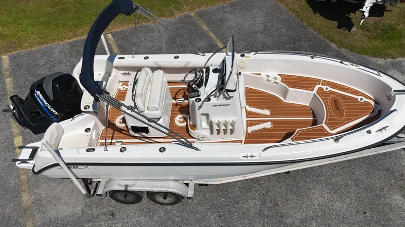 Slide: The Image of 2003 Boston Whaler 21 Outrage boat on trailer, featuring sleek design and spacious deck. - 13