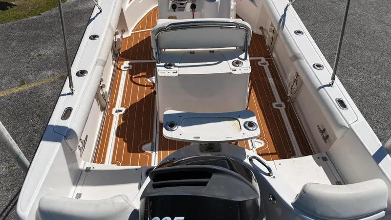Slide: The Image of 2003 Boston Whaler 21 Outrage boat interior with seating and wooden deck. - 7