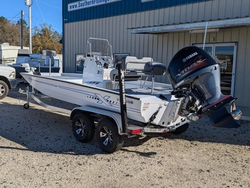 Slide: The Image of 2025 Xpress H210B boat with Yamaha engine on trailer, parked outside a building. - 3