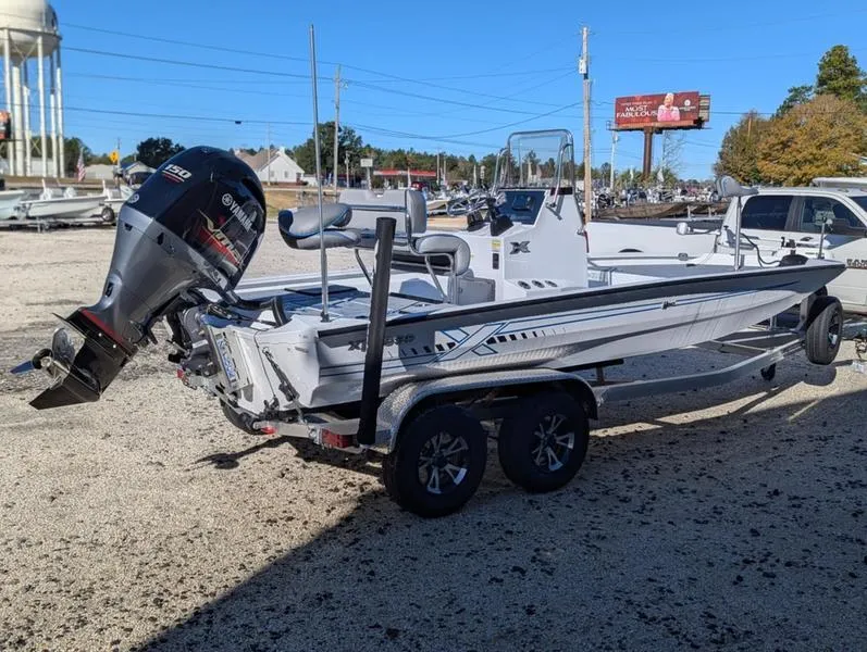 Slide: The Image of 2025 Xpress H210B boat with Yamaha outboard motor on a trailer in a parking lot. - 7