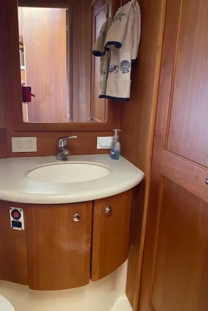 Slide: The Image of 2003 Silverton 35 MY yacht interior bathroom with white fixtures and wooden door. - 33