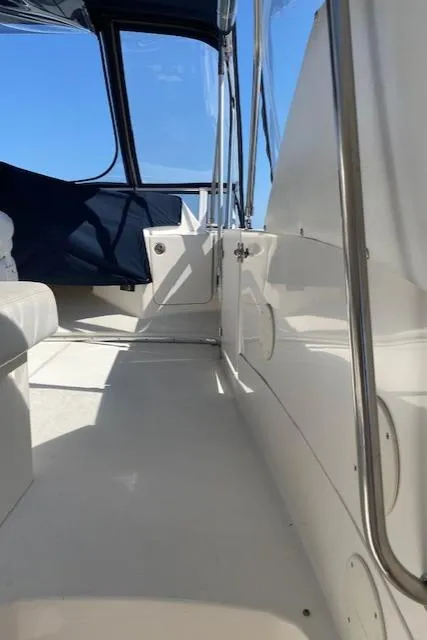 Slide: The Image of 2003 Silverton 35 MY yacht helm with steering wheel and control panel, docked by a scenic waterfront. - 6