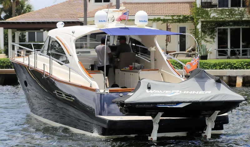 Slide: The Image of 2013 Austin Parker Open 42 yacht with WaveRunner, docked near waterfront property. - 2