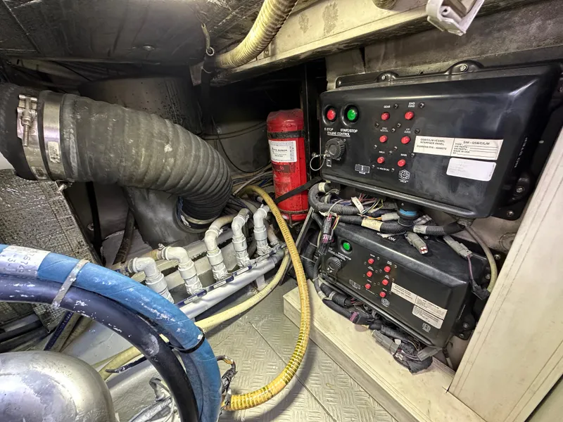 Slide: The Image of Engine room of a 2013 Austin Parker Open 42 yacht, featuring control panels and hoses. - 40