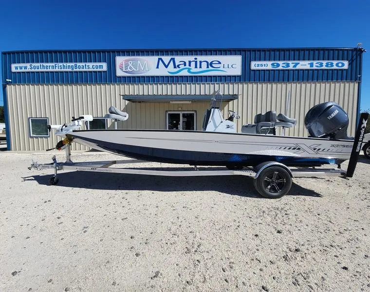 Slide: The Image of 2025 Xpress H22 Bay boat on trailer outside marine dealership. - 0