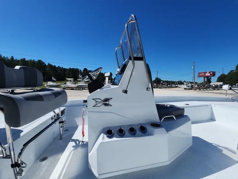 Slide: The Image of 2025 Xpress H22 Bay boat console with seating, under clear blue sky. - 12