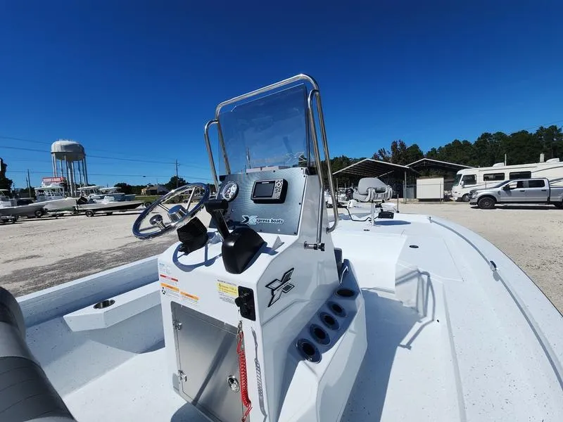 Slide: The Image of 2025 Xpress H22 Bay boat with console and steering wheel in a sunny outdoor setting. - 14