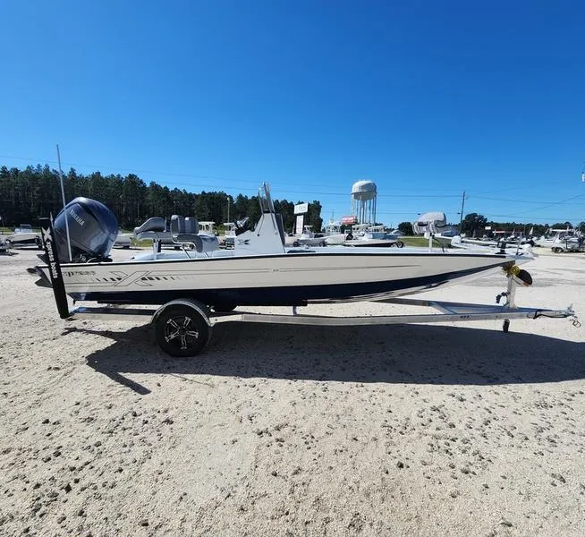 Slide: The Image of 2025 Xpress H22 Bay boat on trailer under clear blue sky. - 2