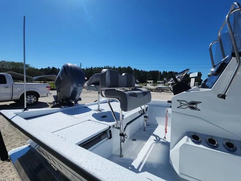 Slide: The Image of 2025 Xpress H22 Bay boat with seating and console, parked outdoors under clear blue sky. - 6