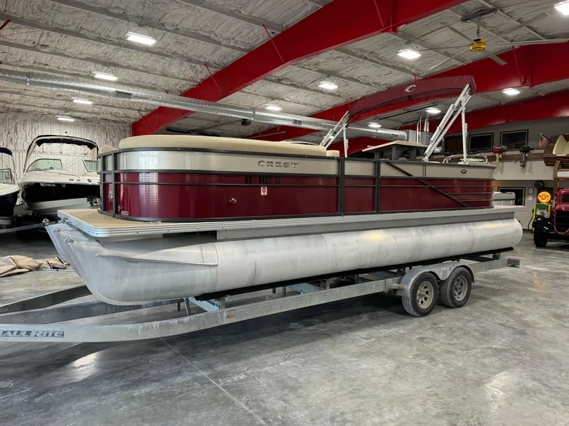 Slide: The Image of 2016 Crest 250 pontoon boat on trailer in indoor storage facility. - 1