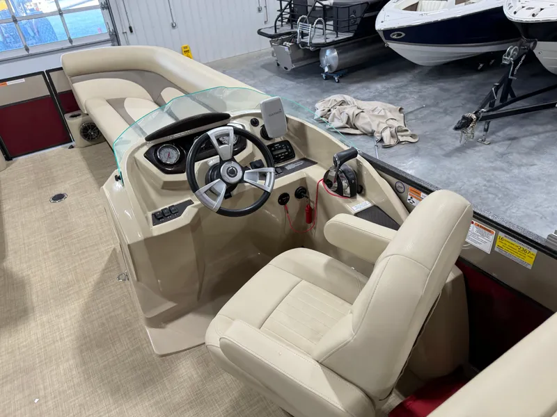 Slide: The Image of 2016 Crest 250 boat interior with steering wheel and beige seating in a showroom. - 12
